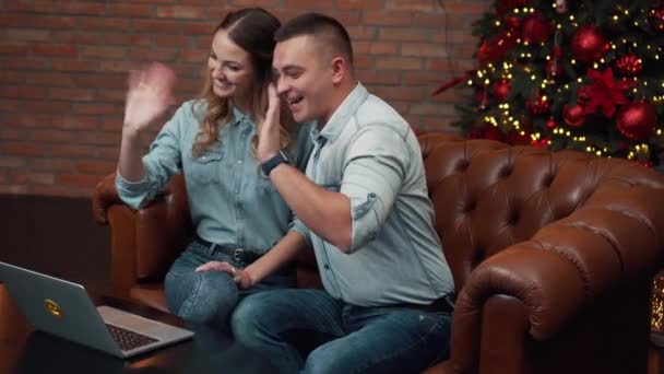 Молодая пара болтает с родственниками через веб-камеру — стоковое видео