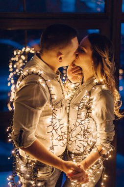 couple in love hugging in dark among multitude of lights clipart