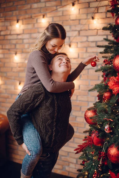 Jovem casal vestir árvore de xmas em casa — Fotografia de Stock
