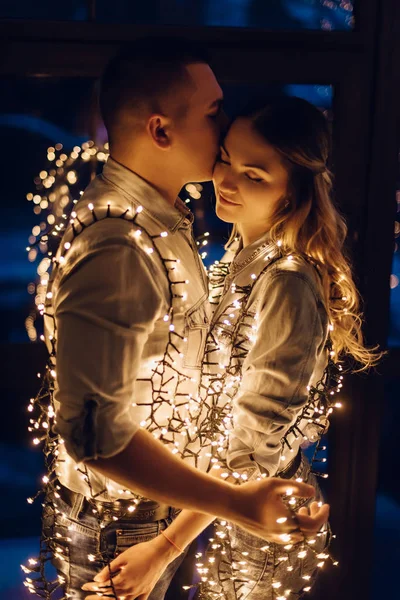 Pareja enamorada abrazándose en la oscuridad entre multitud de luces —  Fotos de Stock