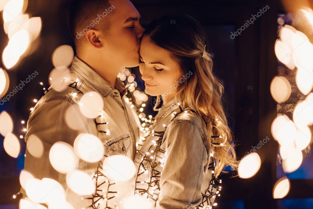 couple in love hugging in dark among multitude of lights