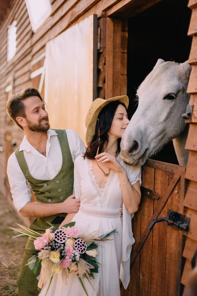 Stylish newlyweds hugging near horse, country style — Stock Photo, Image