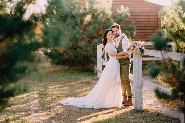 Stijlvolle, romantische paar staande en knuffelen op de ranch — Stockfoto