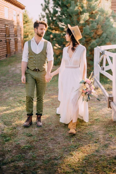 Les jeunes mariés de style boho marchent sur le ranch, jour d'été — Photo