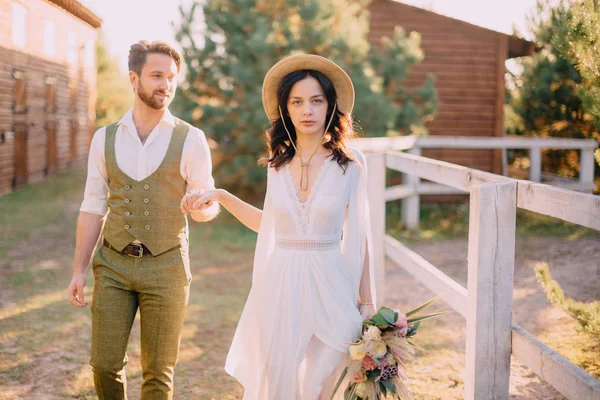 Les jeunes mariés de style boho marchent sur le ranch, jour d'été — Photo