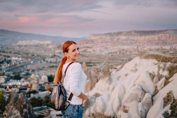 young woman tourist stands against mountain landscape
