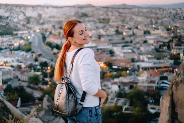 happy woman tourist stands against mountain landscape