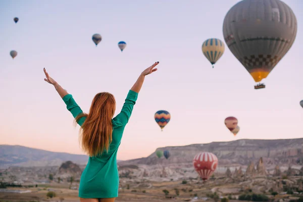 Jonge vrouw op zoek ballonnen armen gestrekt — Stockfoto