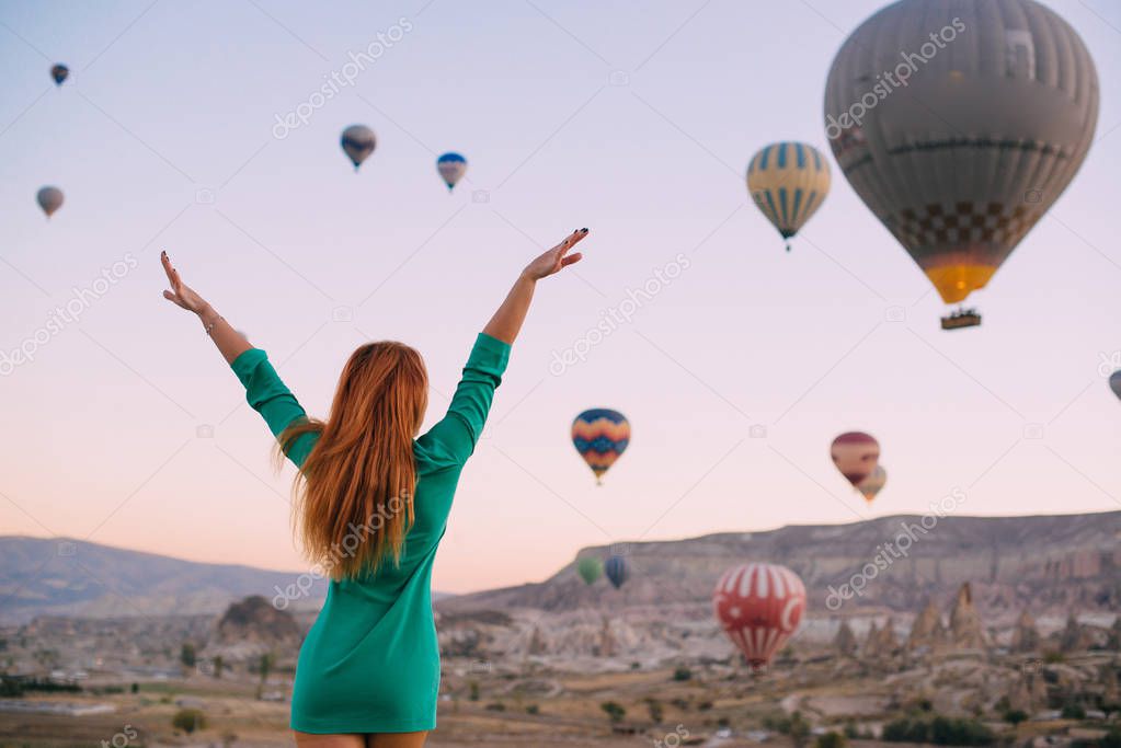 young woman looking balloons arms outstretched