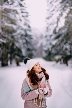 neşeli erkek elinde kahve ile karlı park duruyor