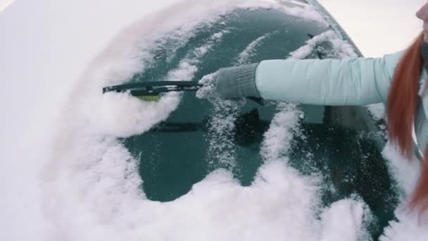 Donna rimuove la neve dal parabrezza della macchina — Video Stock
