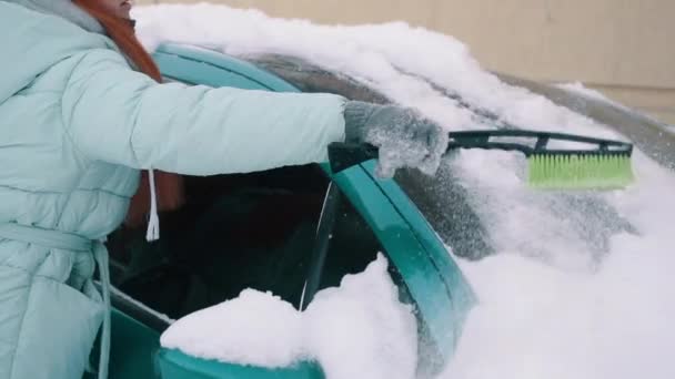 Donna toglie la neve dall'auto con la spazzola — Video Stock