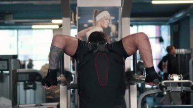 Genç adam paralel bar salonunda, arka görüş üzerinde basılı