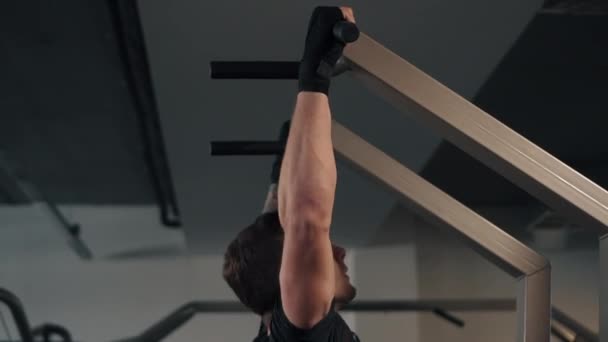 Male athlete pulls himself up on horizontal bar, side view — Stock Video