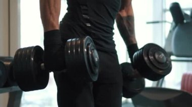 Adam silah elinde dumbbells ile esneme