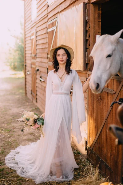 Genç boho stil gelin beyaz at okşayarak — Stok fotoğraf