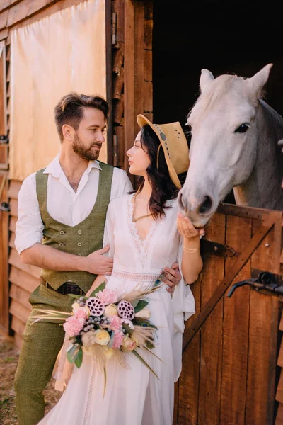 Stylish couple standing and hugging near stables — Stock Photo, Image