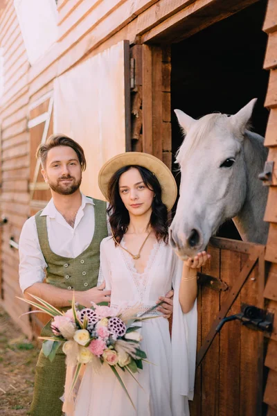 Snygg par stående och kramas nära stallet — Stockfoto