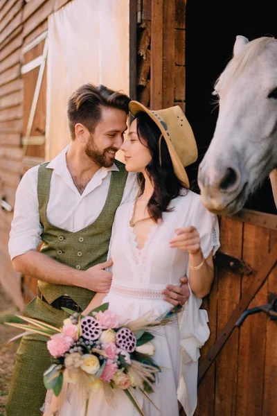 Pareja elegante de pie y abrazos cerca de establos —  Fotos de Stock