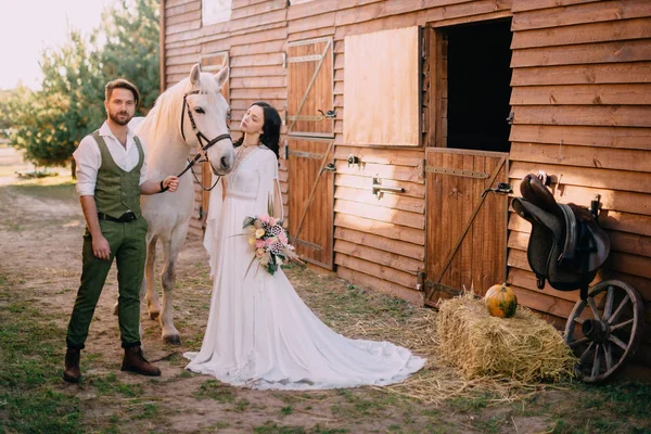 Boho-stijl jonggehuwden permanent in de buurt van paard op ranch — Stockfoto