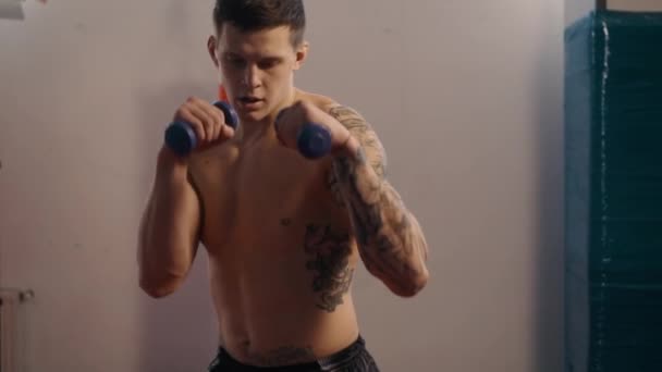 Молодий боксер з татуюваннями тренування в тренажерному залі, повільний рух — стокове відео