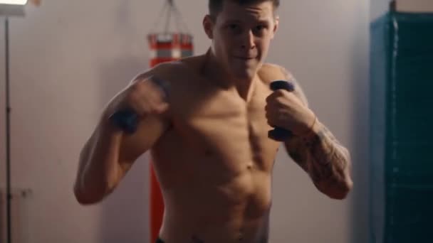 Muž bojovník trénovat údery v tělocvičně — Stock video