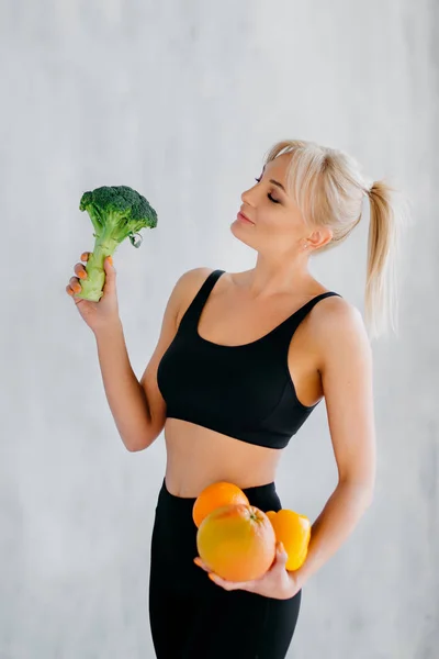 Sportlerin mit frischem Obst und Gemüse in der Hand, gesundes Ernährungskonzept — Stockfoto