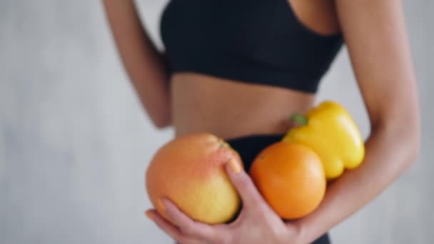 Mulher de esportes segurando frutas e legumes frescos nas mãos, conceito de alimentação saudável — Vídeo de Stock