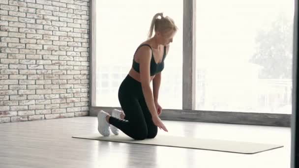 Piękna dziewczyna ćwiczyć cobra asana w studio fitness — Wideo stockowe