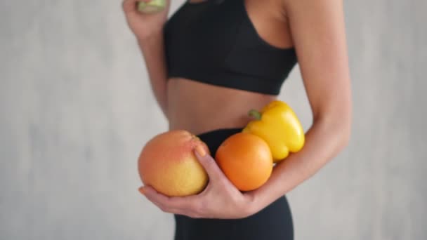 Sport nő, friss gyümölcsök és zöldségek tartja kezében, egészséges táplálkozási koncepció — Stock videók