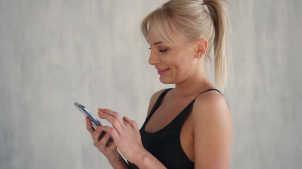 Sorrindo mulher apto mostrando tela verde do telefone móvel, aplicativo de esportes — Vídeo de Stock