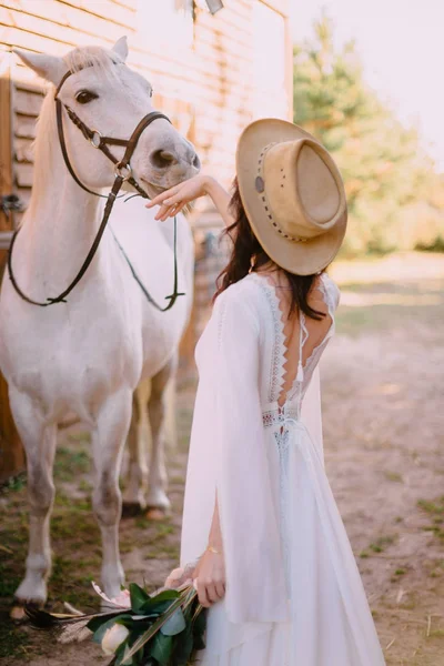 Cowboy style bride stands with her back to camera — Stock Photo, Image