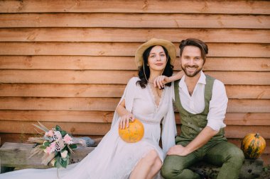 Stil boho oturup giyinmiş ve evin duvara sarılma bir çift
