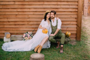 Stil boho oturup giyinmiş ve evin duvara sarılma bir çift