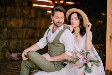 Kovboy tarzı yeni evliler samanlığa birbirlerinin kollarında eşiğinde oturmak