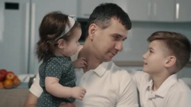 Mutlu genç aile evde koltukta oturan eğlenceler