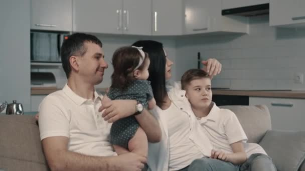 Familia feliz sentada en el sofá en casa — Vídeo de stock