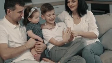 mutlu aile evde kanepede Smartphone kullanarak