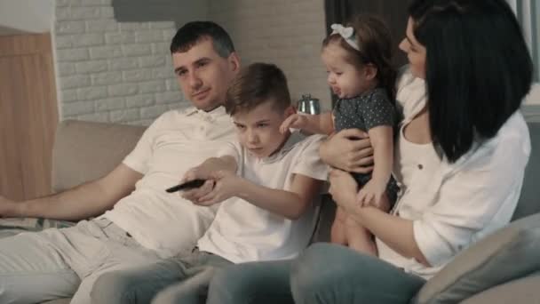 Família feliz assistindo tv em casa no sofá — Vídeo de Stock