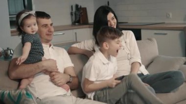 Mutlu aile evde TV izlerken kanepede