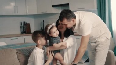 Mutlu bir aile evdeki koltukta oturuyor.