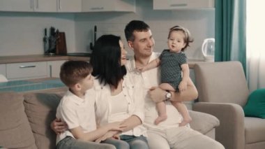 Mutlu bir aile evdeki koltukta oturuyor.