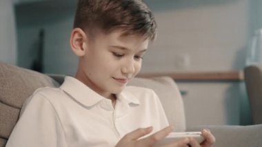Çocuk kullanır smartphone kanepede otururken yakın çekim