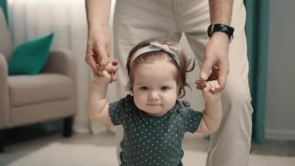 Kleines Mädchen Macht Erste Schritte Mit Hilfe Ihres Vaters Hause — Stockvideo