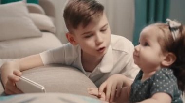 Smartphone ekran küçük kız kardeşi evde gösterilen çocuk