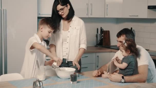 キッチンで夕食を一緒に作って若い幸せな家族 — ストック動画