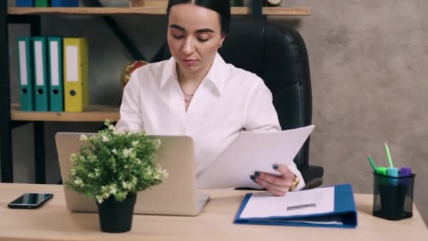 Mladá žena pracuje s dokumenty v kanceláři — Stock video
