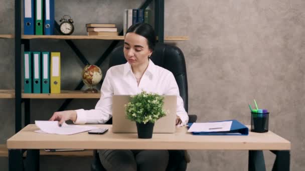 Mujer joven trabaja con documentos en la oficina — Vídeos de Stock