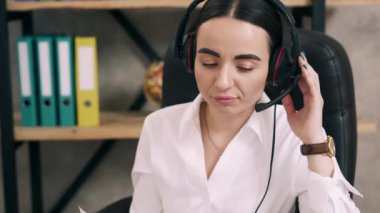 Kadın çağrı merkezi çalışanı müşteri çağrısına cevap veriyor.