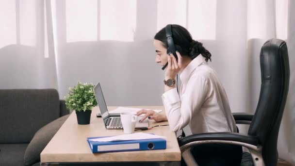 Kadın çağrı merkezi çalışanı ofisteki müşteri çağrısına cevap veriyor. — Stok video